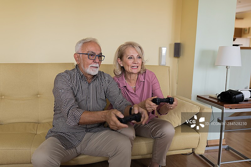 重返童年：退休人员玩电子游戏，乐享美好时光图片素材