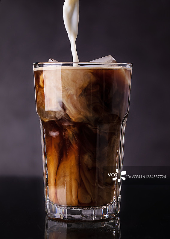 牛奶倒入冰咖啡杯中图片素材