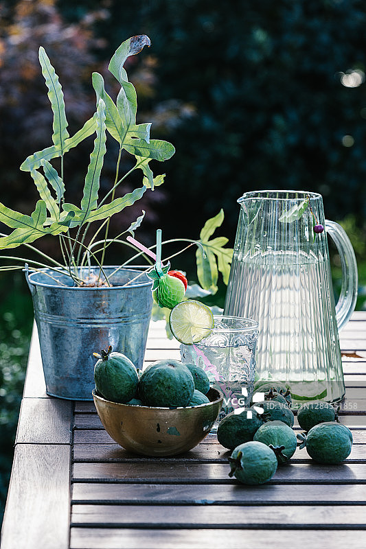 木桌上的柠檬水和绿色番石榴水罐图片素材