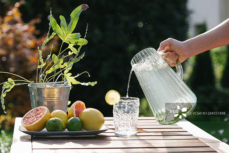 手持玻璃杯装的西柚柠檬水图片素材