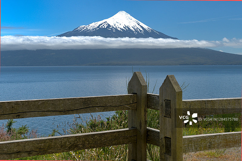 巴塔哥尼亚蓝色湖泊和木栅栏旁的美丽雪火山，智利瓦拉斯港图片素材
