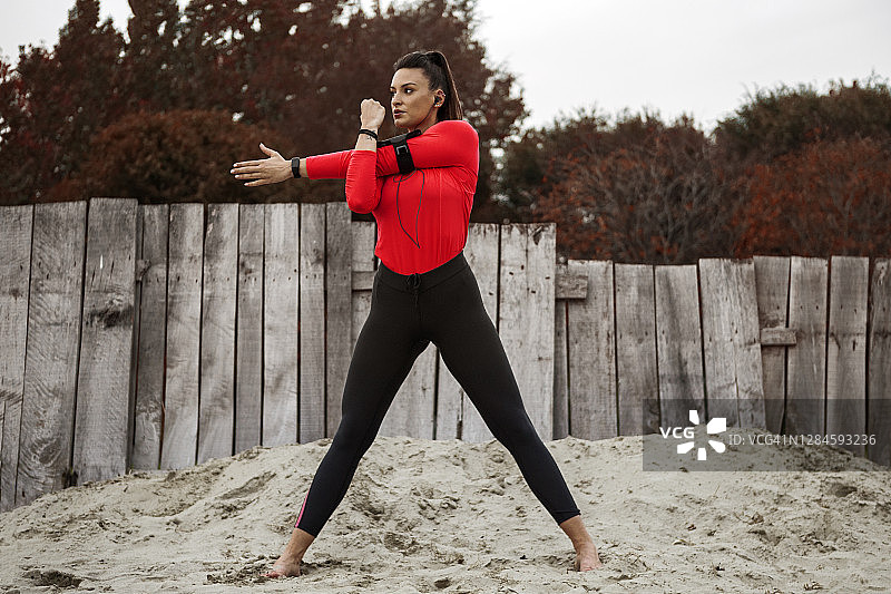 在海滩伸展双手的年轻女人图片素材