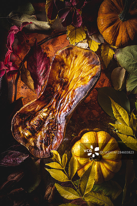 烤制的冬南瓜与生南瓜和秋叶图片素材