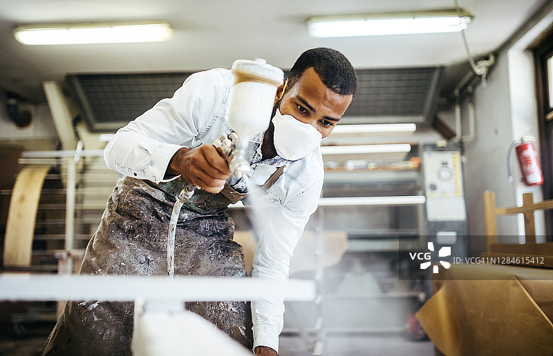 木匠用喷枪喷涂桌子图片素材
