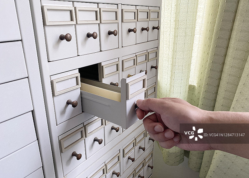 男人拉开一个小抽屉图片素材