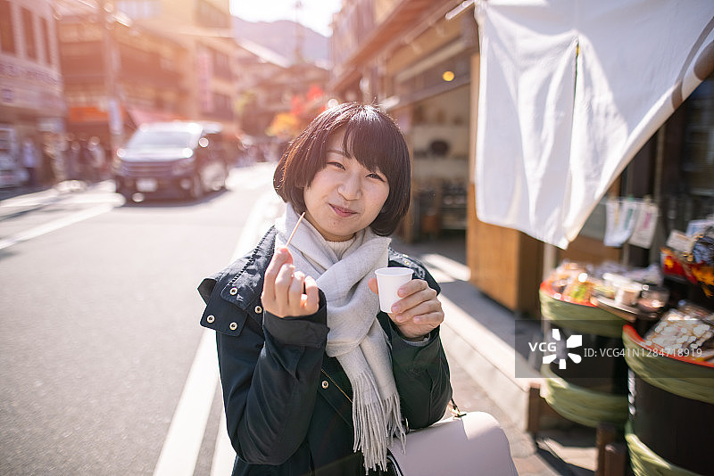 年轻女子在街头景点吃喝图片素材