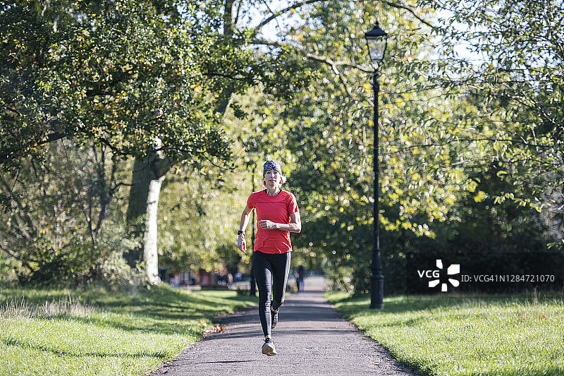 50多岁的健康运动女性在公园跑步图片素材
