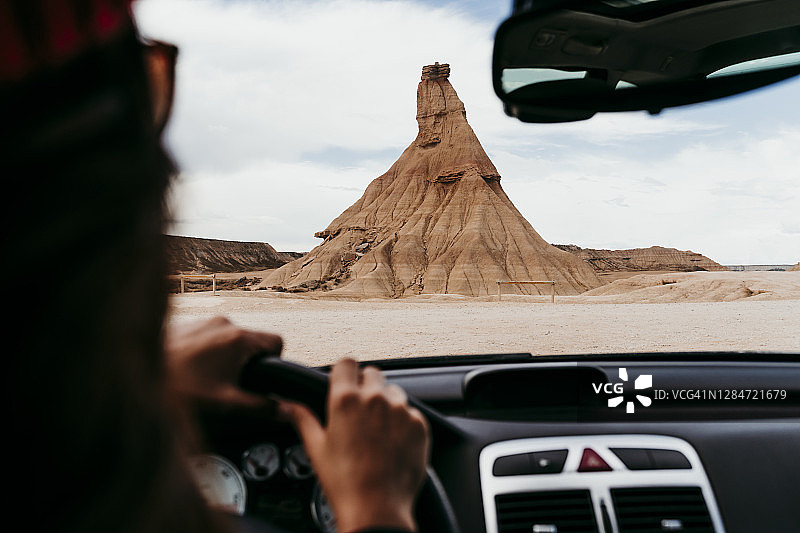 西班牙纳瓦拉：年轻女子驾车前往巴尔德纳斯雷亚莱斯的砂岩地层图片素材
