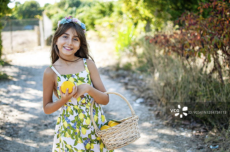 在有机橘子树前摆姿势的美丽女孩图片素材