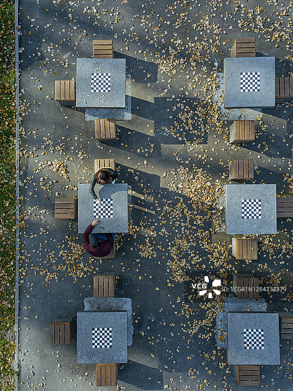 秋季，情侣在公园的桌子上玩象棋图片素材