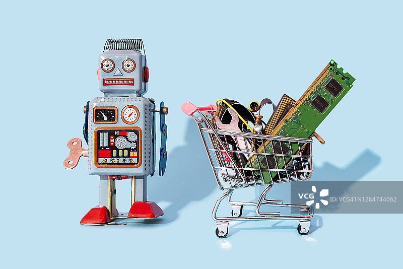 复古机器人玩具和装满电子设备的购物车影棚照片图片素材
