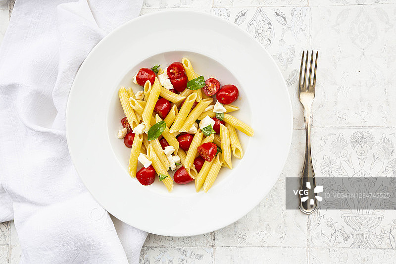 配有马苏里拉奶酪、小番茄和罗勒的素食意大利面图片素材