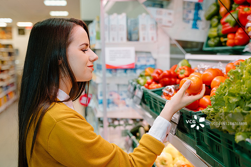 在商店里挑选番茄的女人图片素材