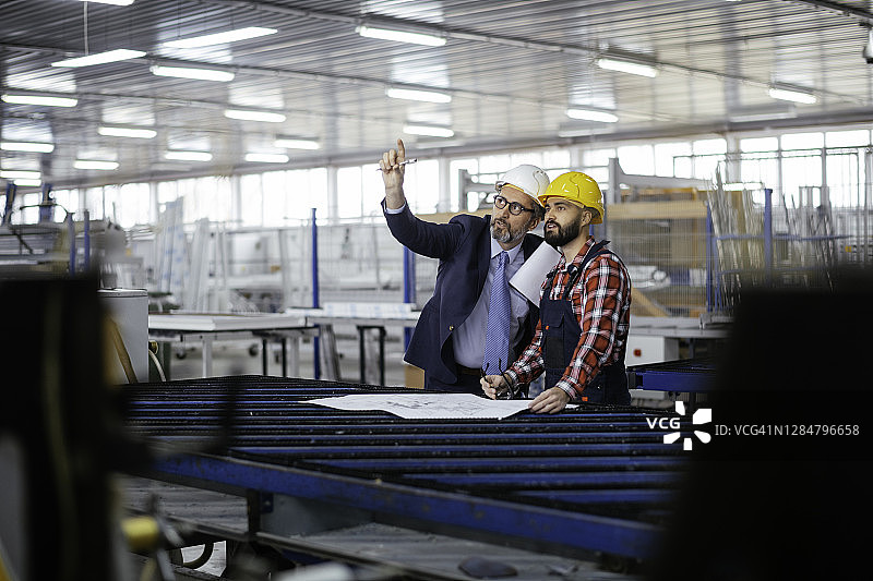 年轻工程师与质检员在工厂车间图片素材