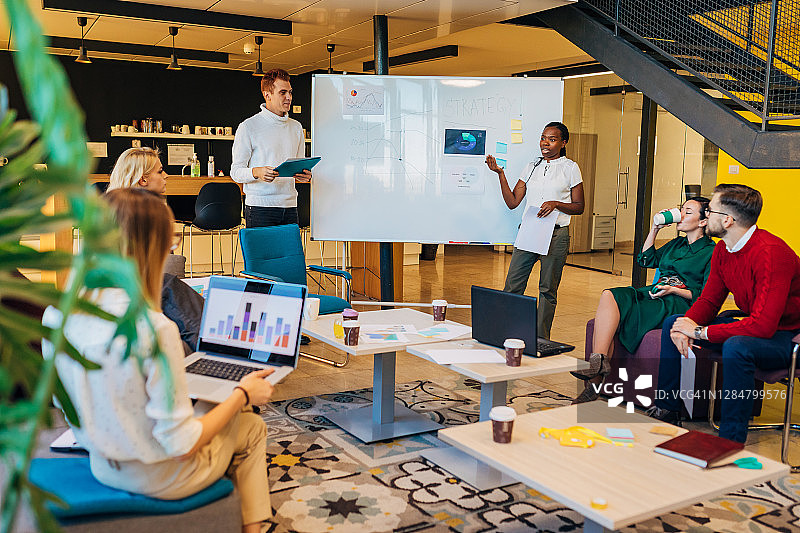 自信的女商人与员工开会，在白板上进行图表演示图片素材
