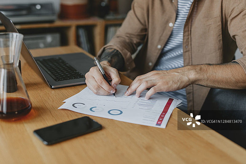 在家办公：年轻商人为公司进行数据分析，适应新常态概念图片素材