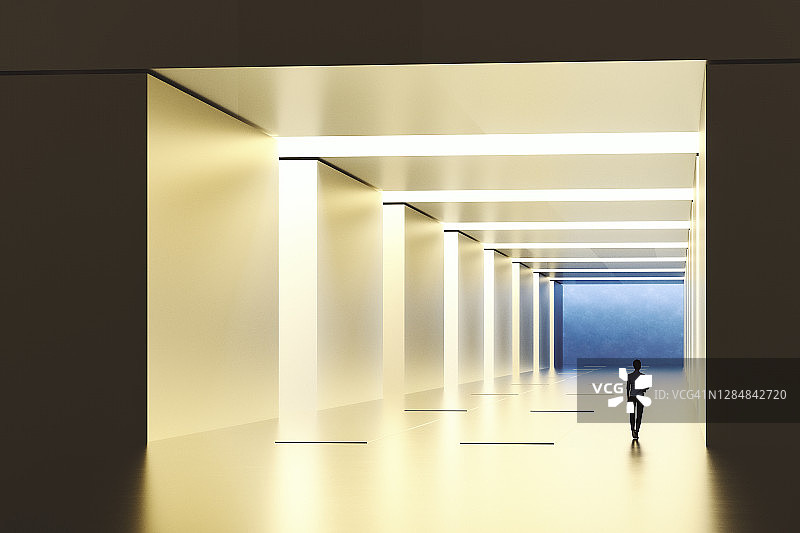 在灯光明亮的走廊中行走的商务女性图片素材