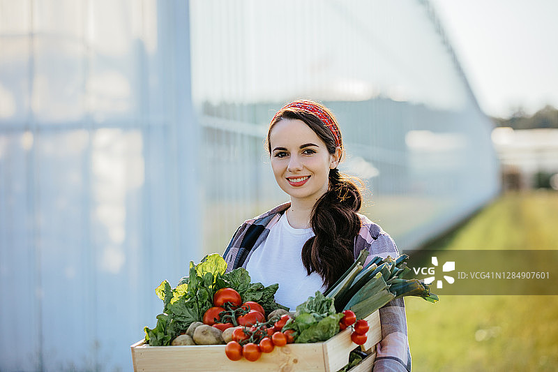 女人在温室外搬运蔬菜筐图片素材