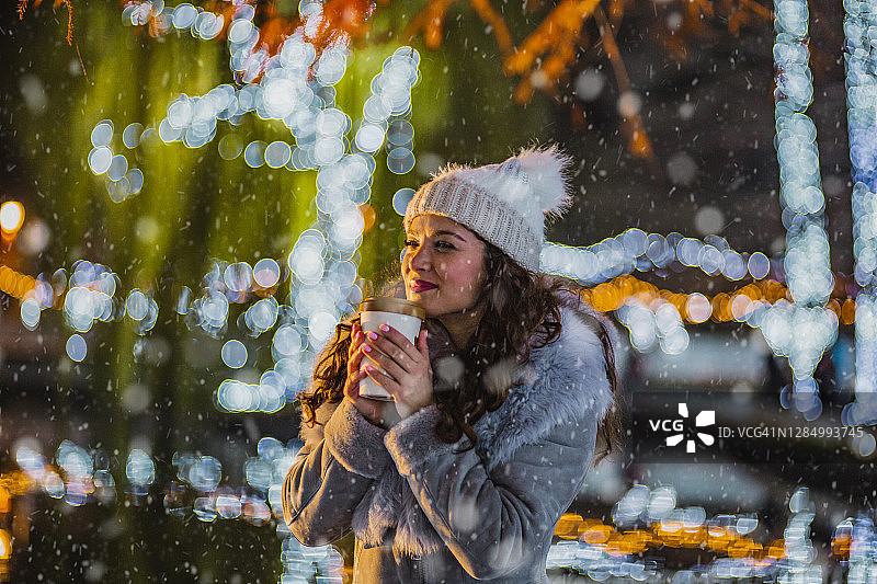 年轻女人在户外享用热饮图片素材