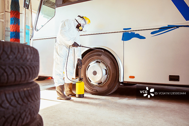 身穿白色化学防护服的男子正在消毒图片素材