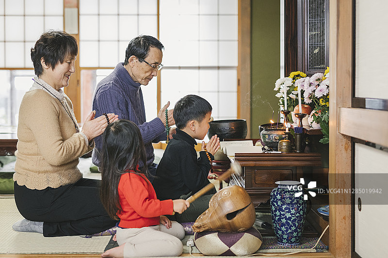 日本多代同堂家庭在佛坛前祈祷图片素材