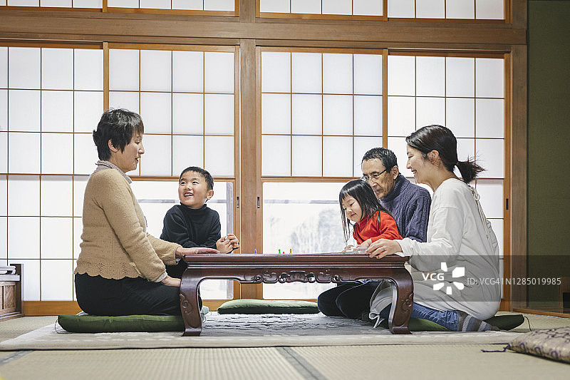 亚洲多代同堂家庭一起玩棋盘游戏图片素材