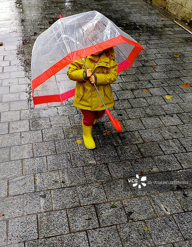 穿黄色雨衣和靴子打伞的小女孩图片素材