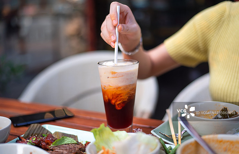 饭后，女人混合泰式奶茶和冰块图片素材