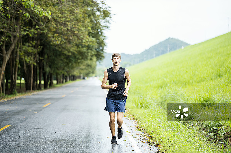 在早晨的街道上跑步的白人男子图片素材