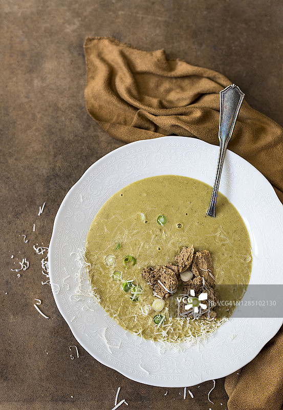乡村木桌上的洋葱汤配面包丁和帕尔马干酪图片素材