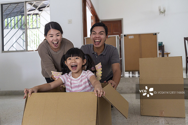 快乐的亚洲女孩在新家纸箱里玩耍图片素材