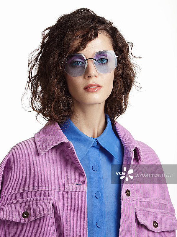 身穿蓝色衬衫、紫色外套和蓝色眼镜的美丽女人图片素材