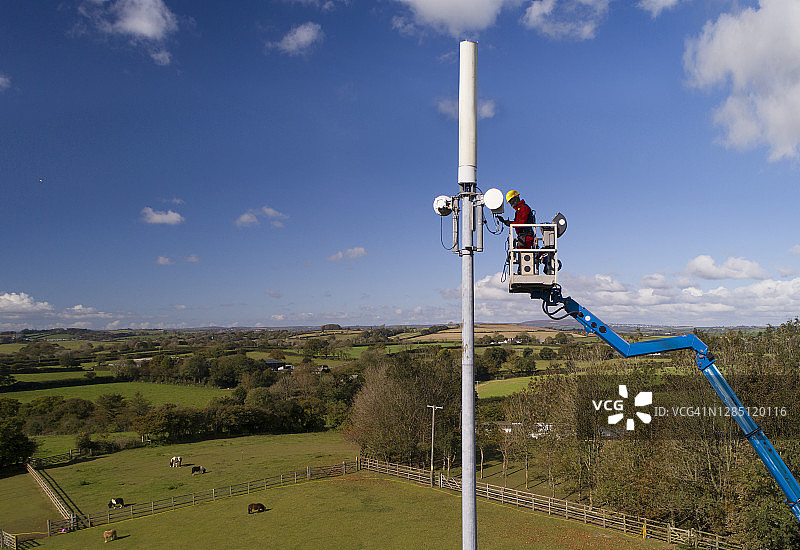 男人在高高的电话杆上工作图片素材