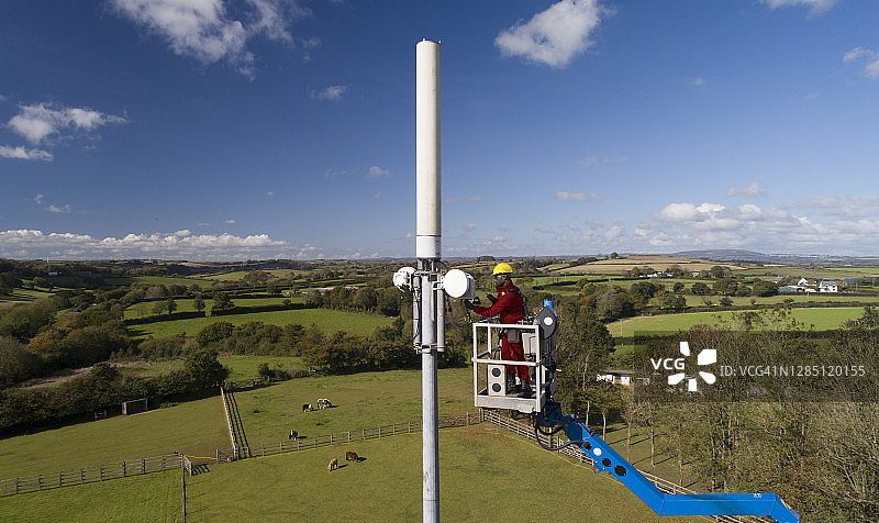 男人在高高的电话杆上工作图片素材