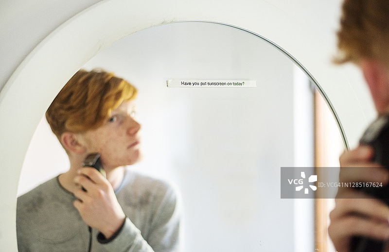 青少年刮胡子时在浴室镜子里看妈妈的便条图片素材