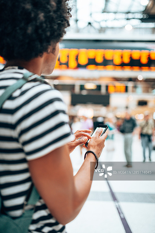 男人在车站看智能手机图片素材