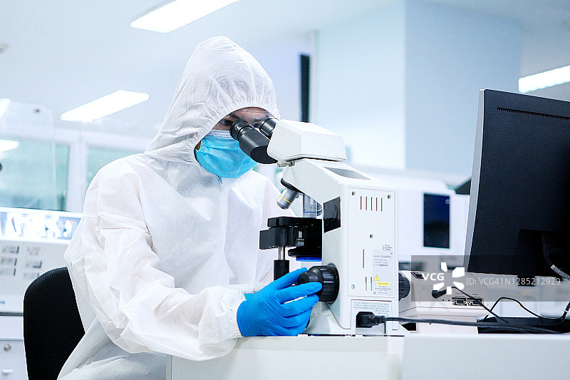 在无菌室中，科学家们正在使用显微镜进行实验，检查血小板的感染情况图片素材