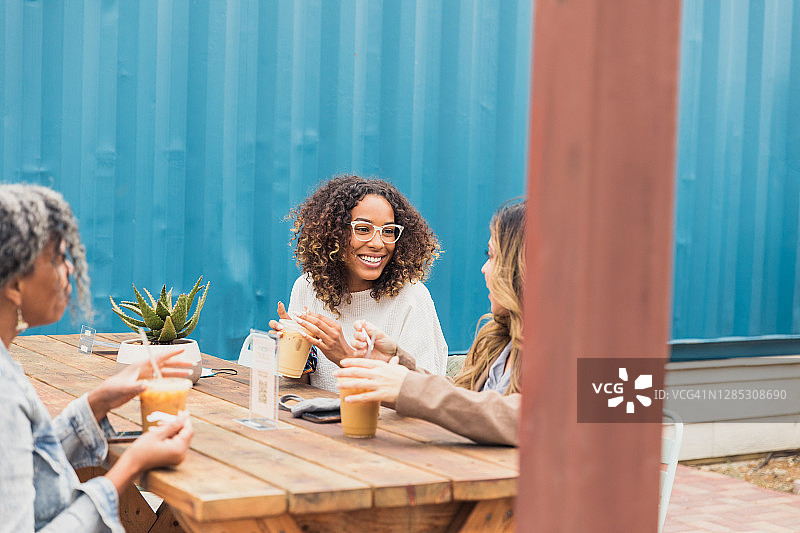 疫情期间三个朋友在户外餐厅相聚图片素材