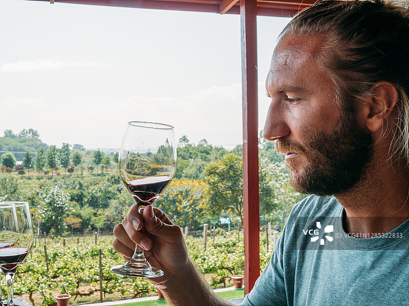 年轻男人在缅甸的葡萄园品酒图片素材