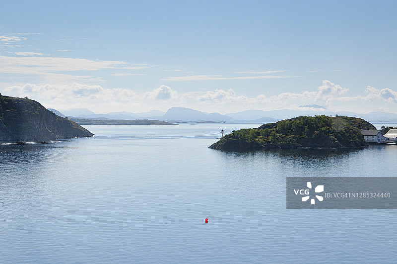 八月晴朗天气下，拥有淡云和湛蓝天空的狭窄海峡图片素材