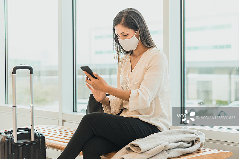 坐在机场或火车站里发短信的女人图片素材