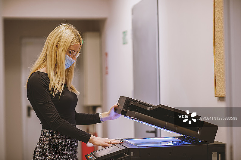 疫情期间在办公室工作的年轻女商人图片素材