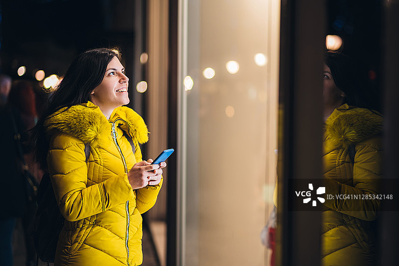 站在商店橱窗前的女人图片素材