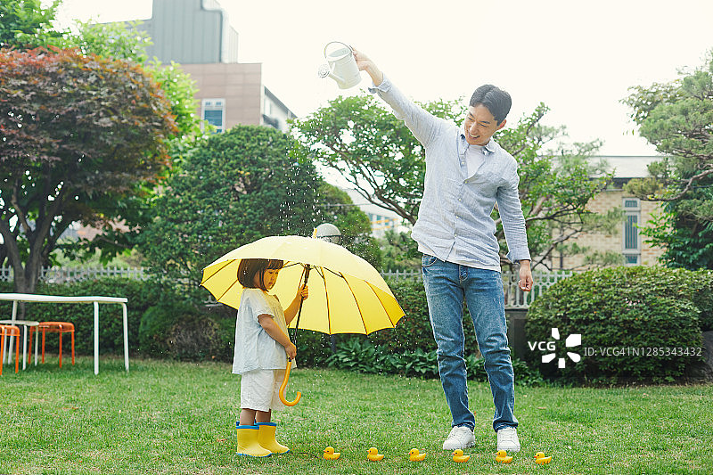 举着黄色雨伞的孩子图片素材