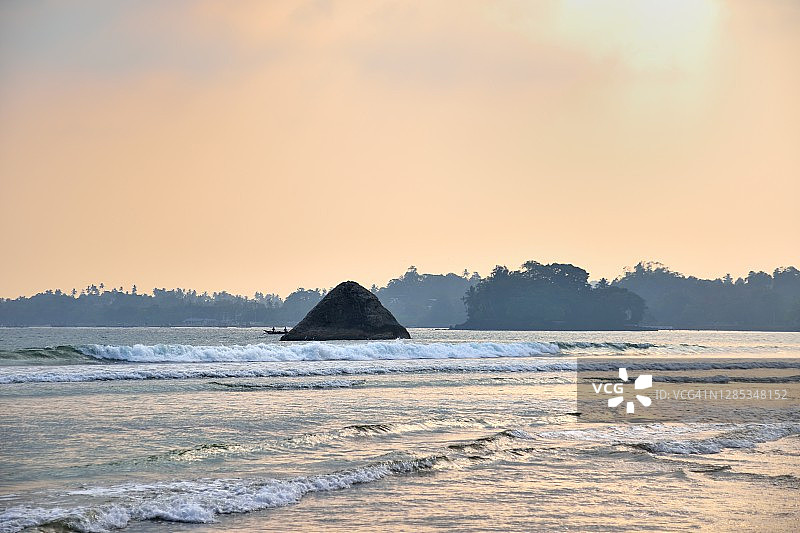 斯里兰卡韦利格默日落沙滩岩石图片素材