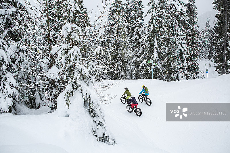 朋友们在加拿大惠斯勒的雪地里骑着胖胎自行车图片素材