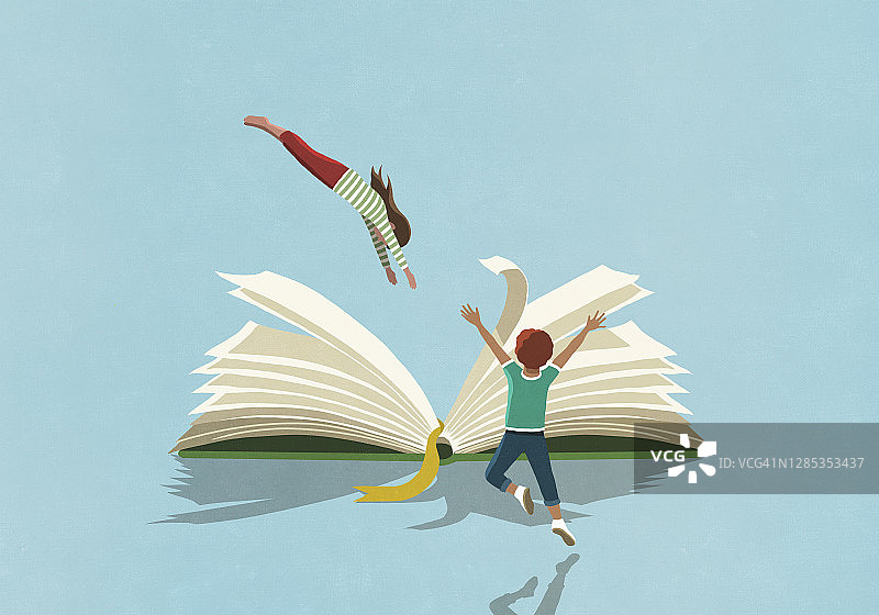 男孩兴高采烈地看着女孩跳进书里图片素材