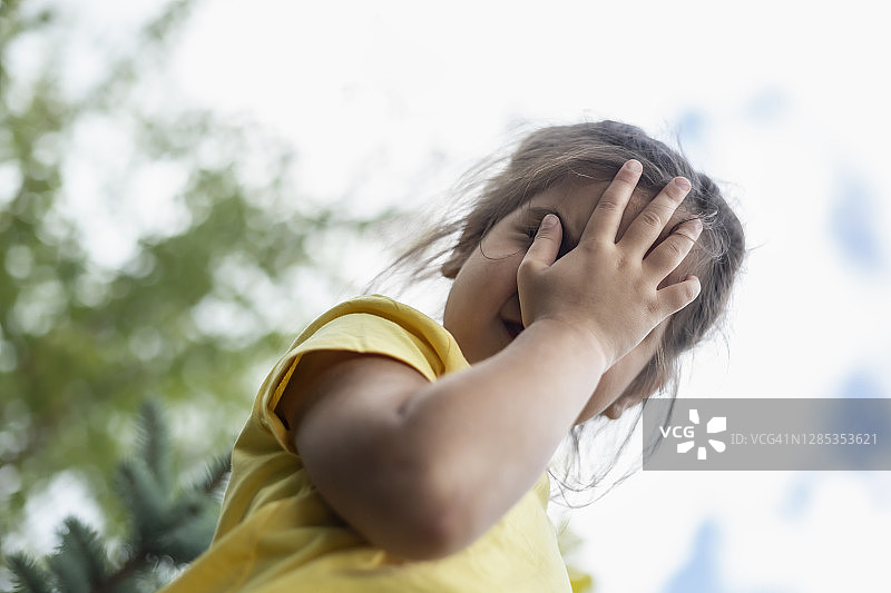 用手遮住脸的可爱害羞女孩人像图片素材
