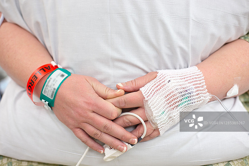 一位孕妇在硬膜外注射期间抱着一个枕头。图片素材