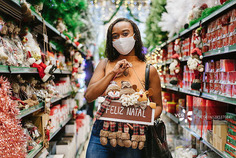 在商店里手拿圣诞装饰品的女人图片素材